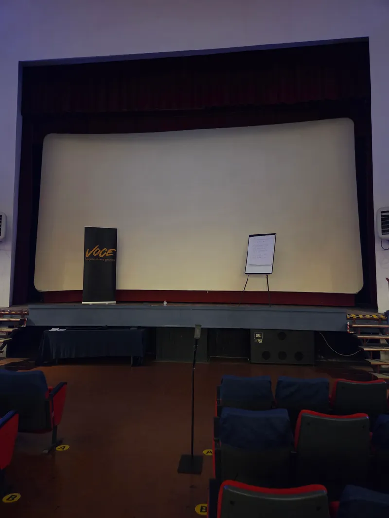 Il palco del teatro con il banner Voce e una lavagna a fogli mobili